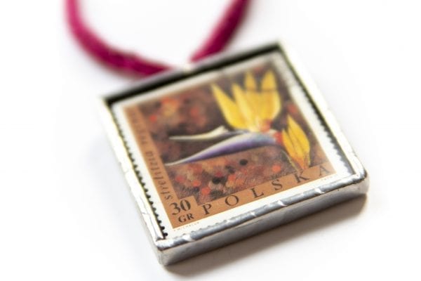 Dzikie Twory - naszyjnik ze znaczkiem pocztowym kwiat strelizia zbliżenie