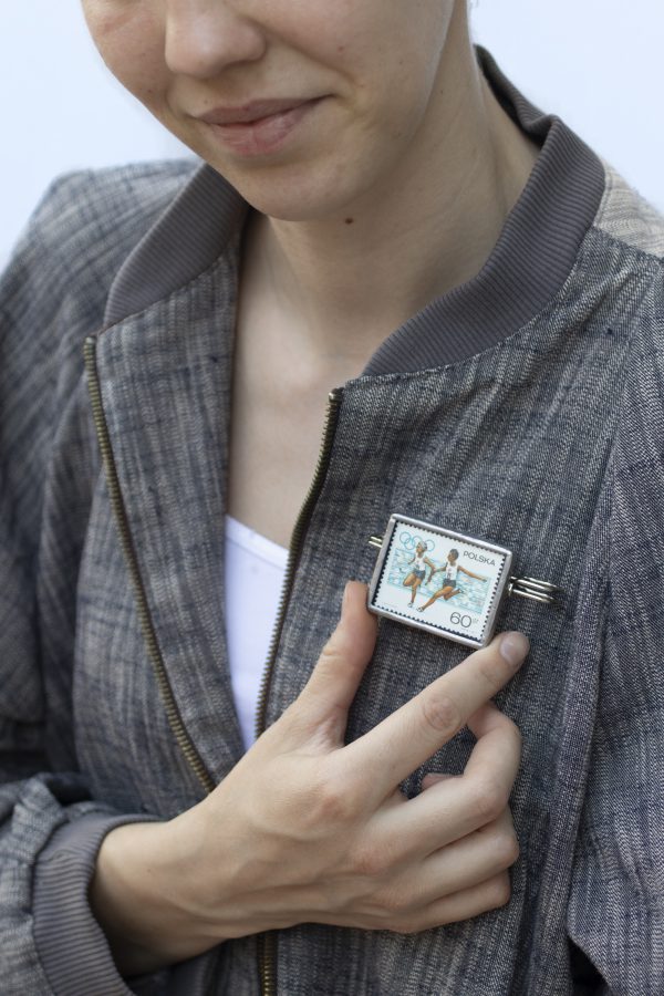 Dzikie Twory - naszyjnik ze znaczkiem pocztowym z 1967 roku, Apel olimpijski, broszka przypięta do kurtki