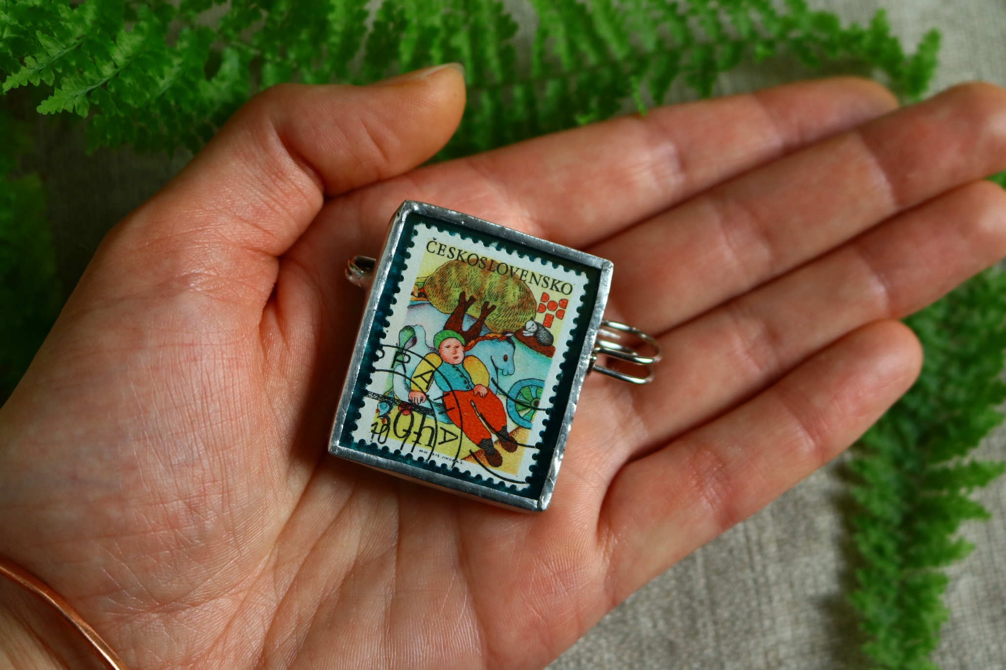 Dzikie Twory - broszka ze znaczkiem pocztowym z 1975 roku z Czechosłowacji - śniąca postać z książki, wielkoś broszki na dłoni